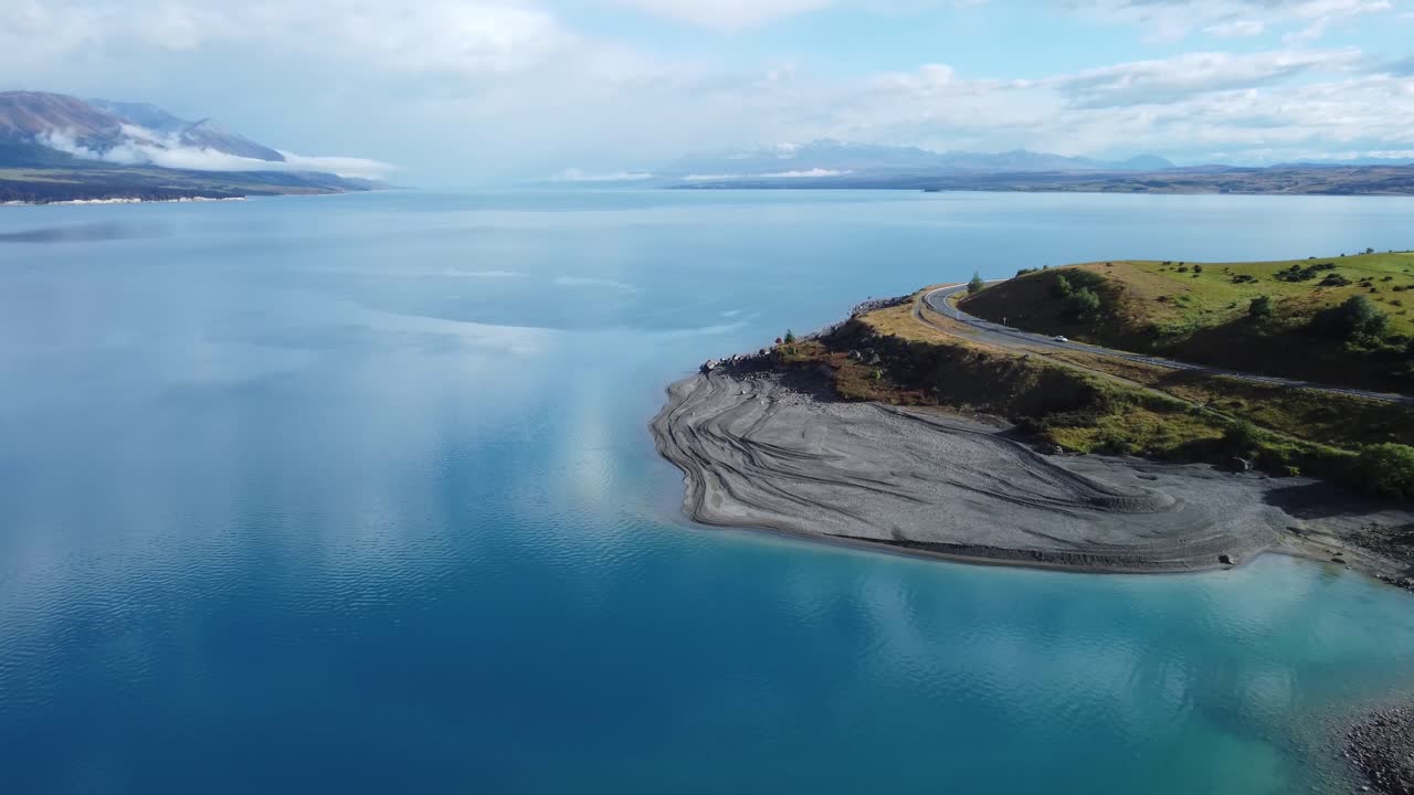 Drone view of blue Lake Pukaki and mountains on a sunny summer day in New Zealand.