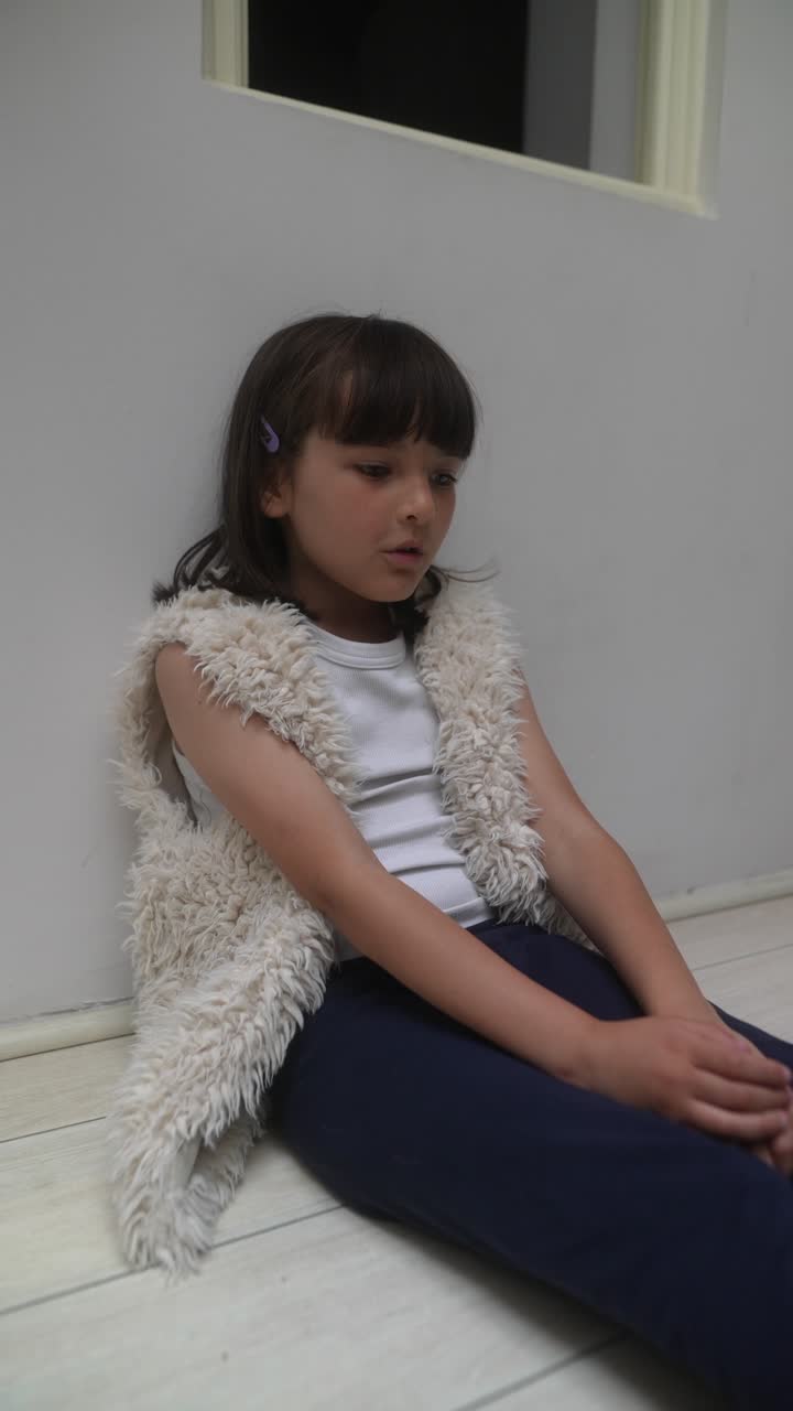 Una chica joven sentada en el suelo.