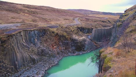 formación de roca de columna de basalto en el cañón de studlagil con agua verde azul