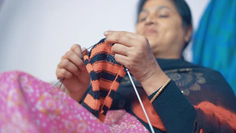 Indische-Frau-Strickt-Schal-Mit-Bastelnadeln-Und-Roter-Und-Schwarzer-Wolle