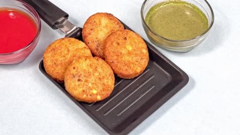 Aloo-Tikki-Ragda-Patties-Cutlet-is-a-popular-snack-or-snack-from-India,-Served-with-Tomato-Ketchup-or-Imli-chutney-over-white-background