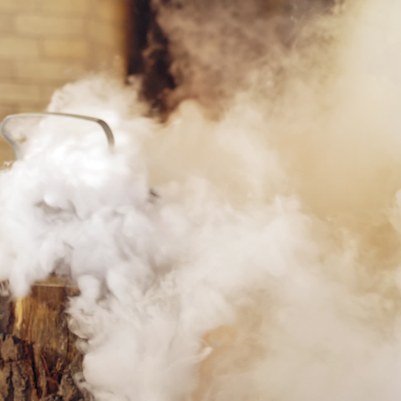 White steam coming from the kettle on a wooden log indoors. Boiling kettle near the fireplace. Santa's hand taking kettle with hot water.
