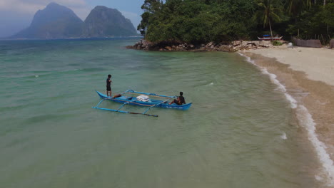 vista de drones de hombres navegando en un bote en una playa tropical