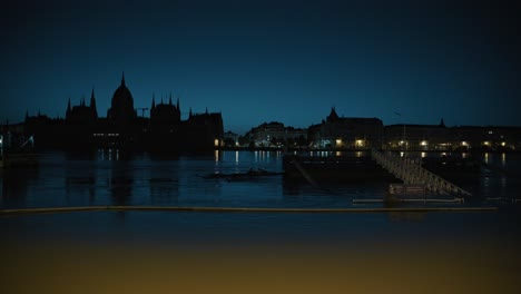 night view of flooded riverbank with silhouette of parliament building, budapest flood 2024