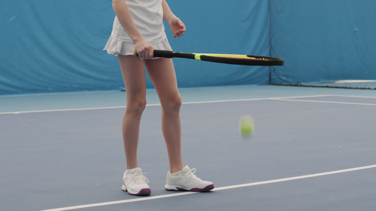 Girl Bouncing Tennis Ball On Floor