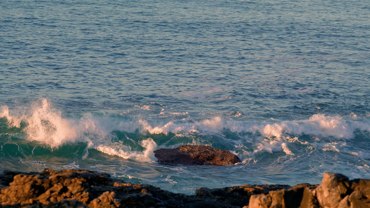 olas tormentosas aplastando la costa en primer plano de verano. el agua del océano rompiendo por los acantilados