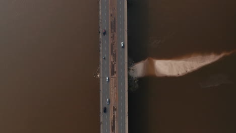 Aerial-birds-eye-overhead-top-down-panning-view-of-wide-multilane-road-bridge-with-tram-tracks-in-middle.-Cars-and-trams-running-on-bridge-and-surrounding-intersection.-Warsaw,-Poland