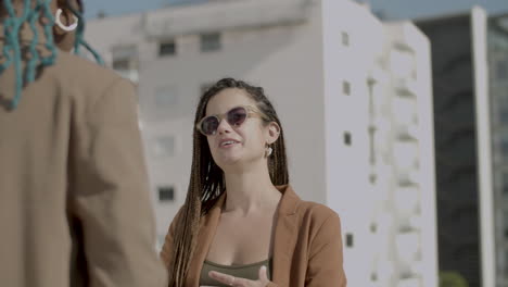 smiling woman having conversation with her colleague outdoor