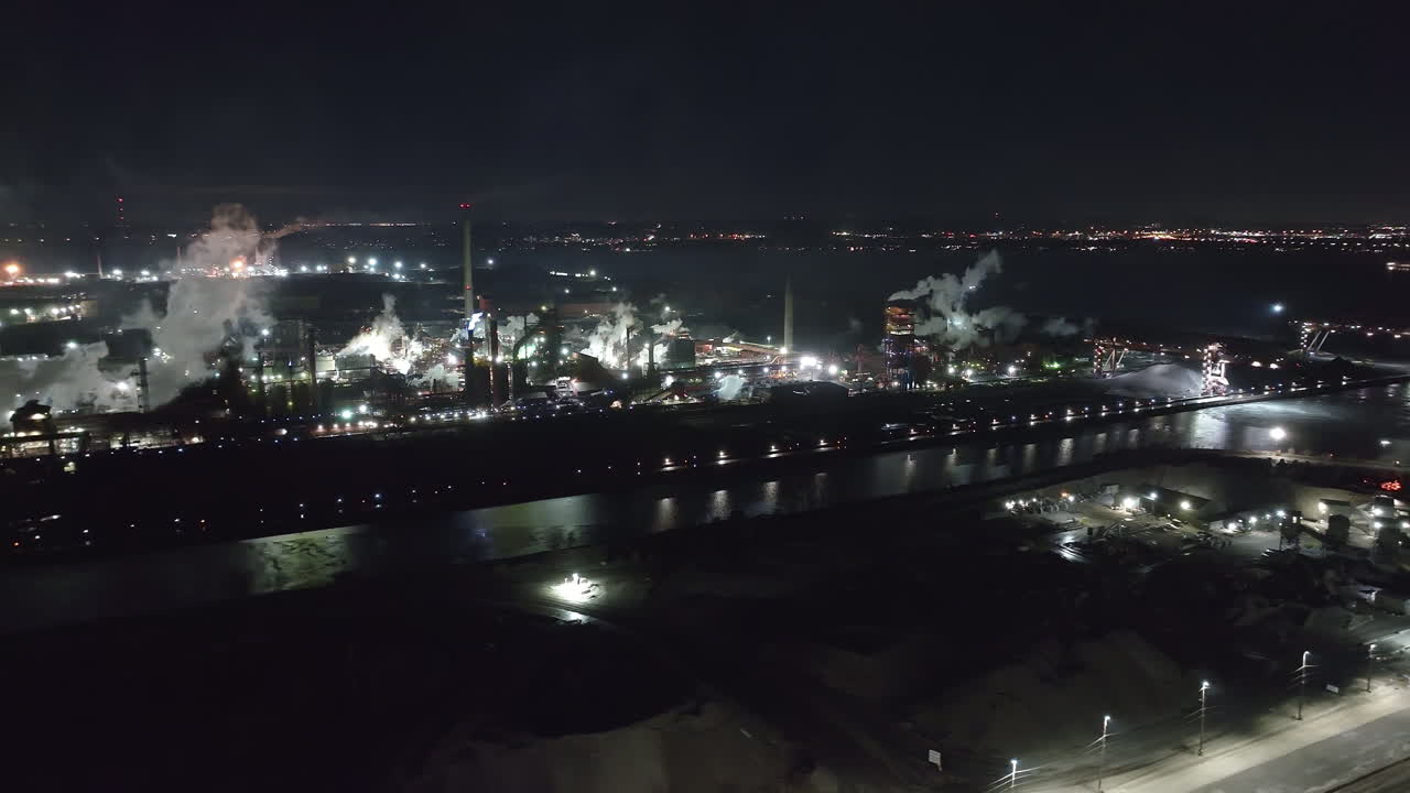 Vista nocturna de un complejo industrial en Hamilton, Ontario, capturando el resplandor urbano.