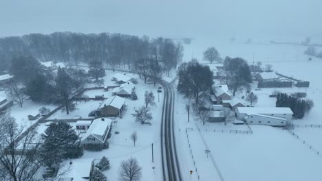 aerial birds eye shot over houses located on snowy hill in america