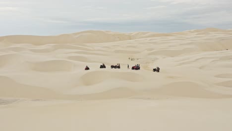 group on atv vehicles parked in brazil desert sand dune landscape