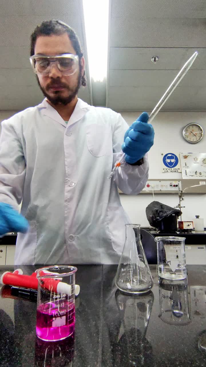 A man in a lab coat is holding a beaker and a test tube