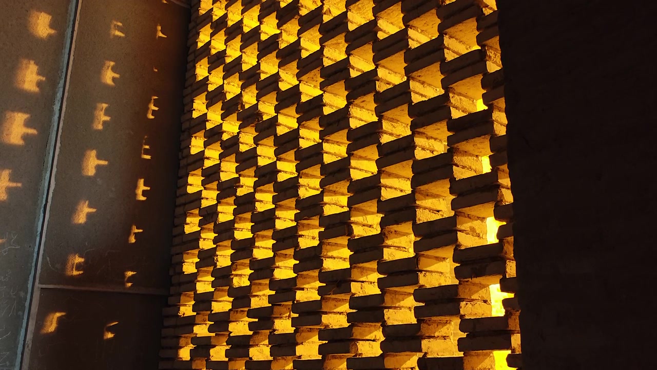 Luz solar proyectando sombras geométricas a través de una pared de ladrillos