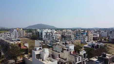 Vista-Aérea-De-Una-Pequeña-Ciudad-Que-Supera-A-Un-Pueblo-En-Indore,-India-I-Combinación-De-Una-Pequeña-Ciudad-Y-Un-Pueblo-Con-Una-Hermosa-Montaña-Al-Fondo