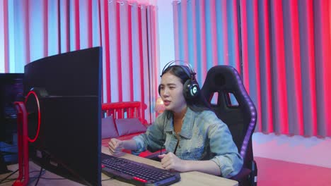 excited girl gamer playing video game on computer and lose