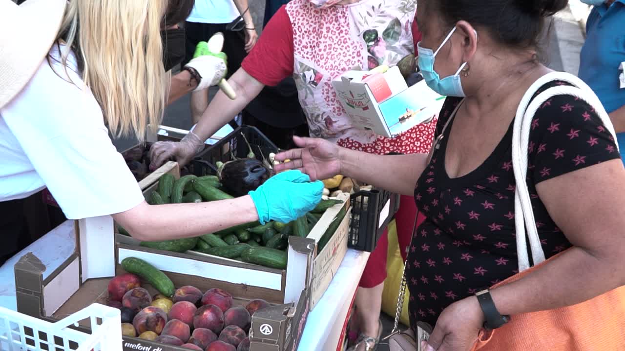 las personas que viven en la pobreza recogen y recogen los restos de comida de jóvenes activistas en milán, italia, durante la pandemia