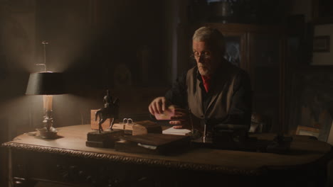 old passionate man read a book in his office at night