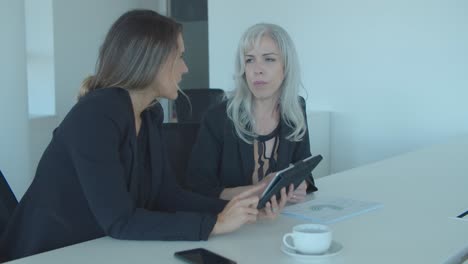 two businesswomen discussing and analyzing reports