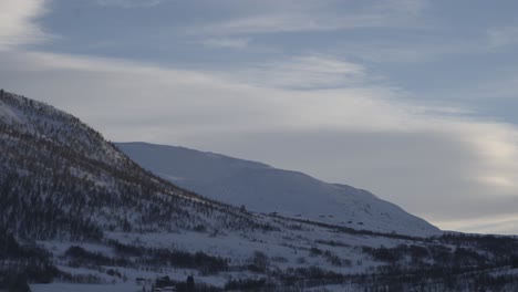 morning sunrise timeliapse at revhaugen in myrkdalen and vikafjell mountain during winter day - light clouds passing and sun slowly hitting mountain peaks