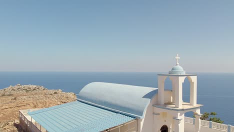 Volar-Sobre-La-Capilla-En-El-Borde-Del-Mar-De-La-Isla-De-Creta,-Chania,-Grecia