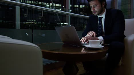 Arabic businessman hotel atrium night using laptop computer