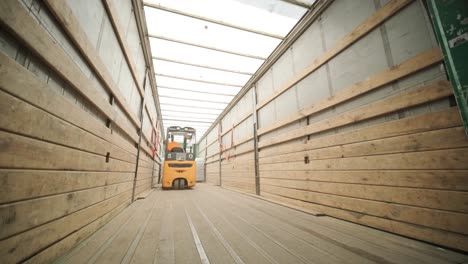 forklift driver transports packaged water bottles in warehouse