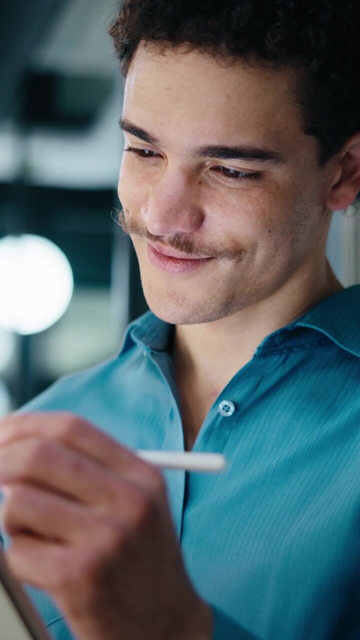 Giovane uomo che usa uno stilo digitale su tablet in un ufficio moderno