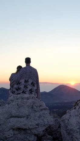 couple watching sunset from mountaintop