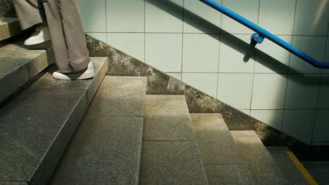 person walking down stairs in underground station