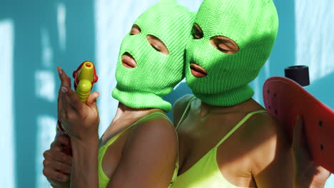 women in neon green masks and bikinis with skateboards