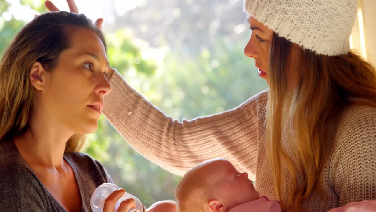 레즈비언 커플이 아기에게 우유를 먹이는 4k