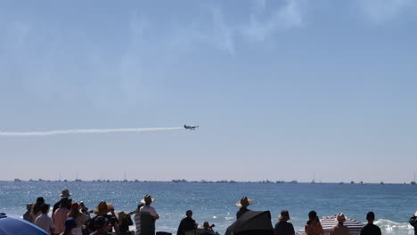 planes performing stunts over crowded beach