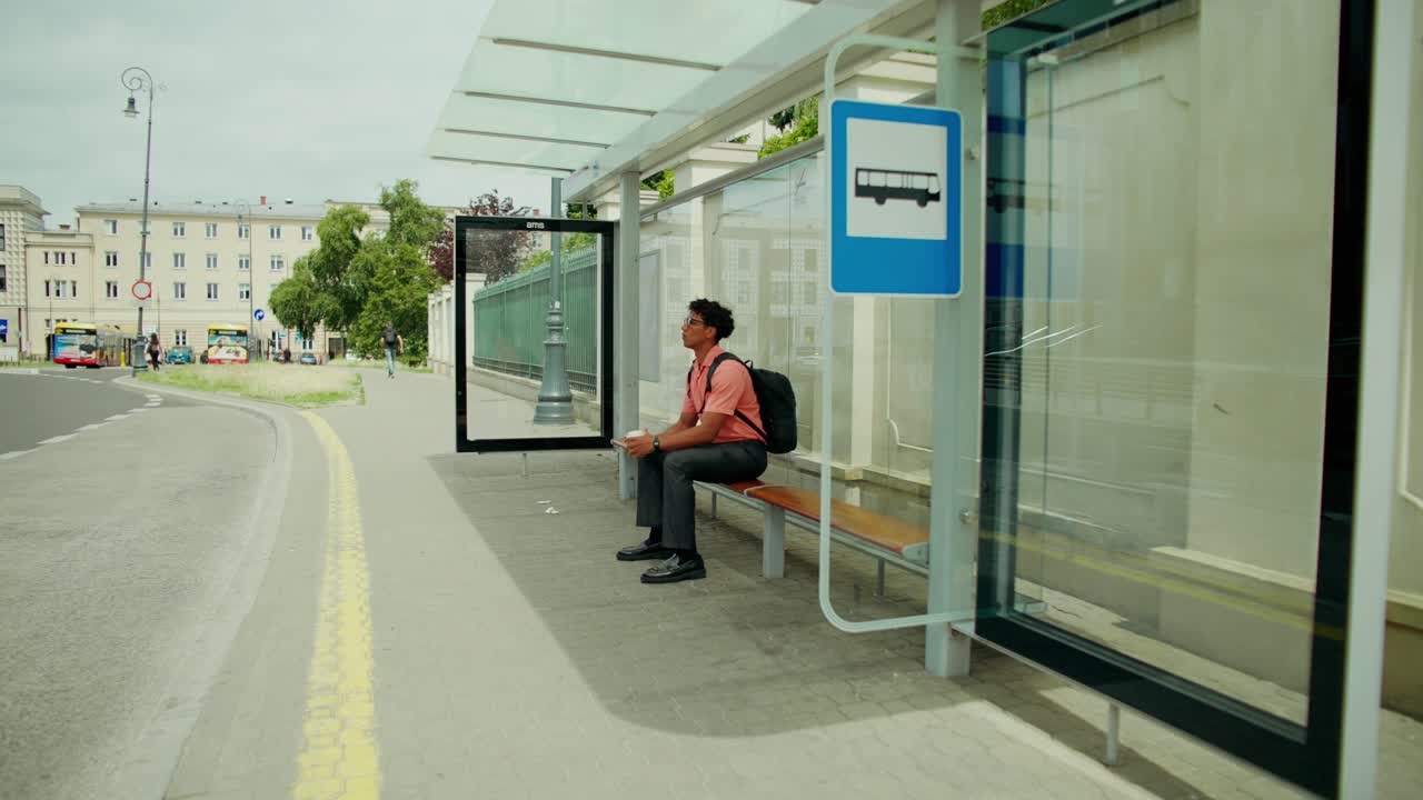 Uomo che aspetta alla fermata dell'autobus