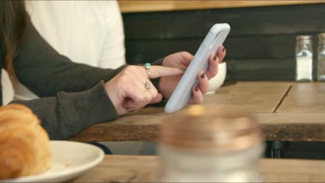 Woman-Using-Phone-in-Cafe