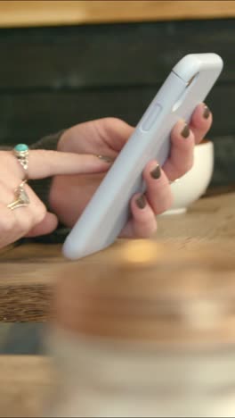 woman using phone in cafe