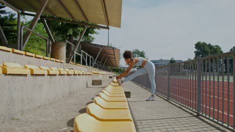 woman stretching outdoors at a stadium