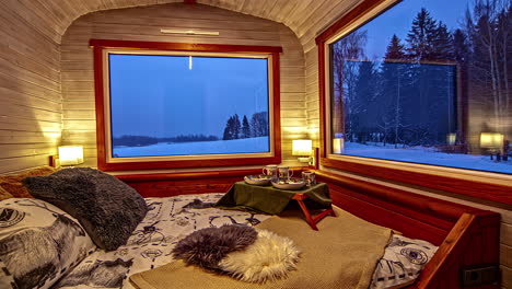 comfortable hotel bedroom with large panoramic windows on rural snowy landscape