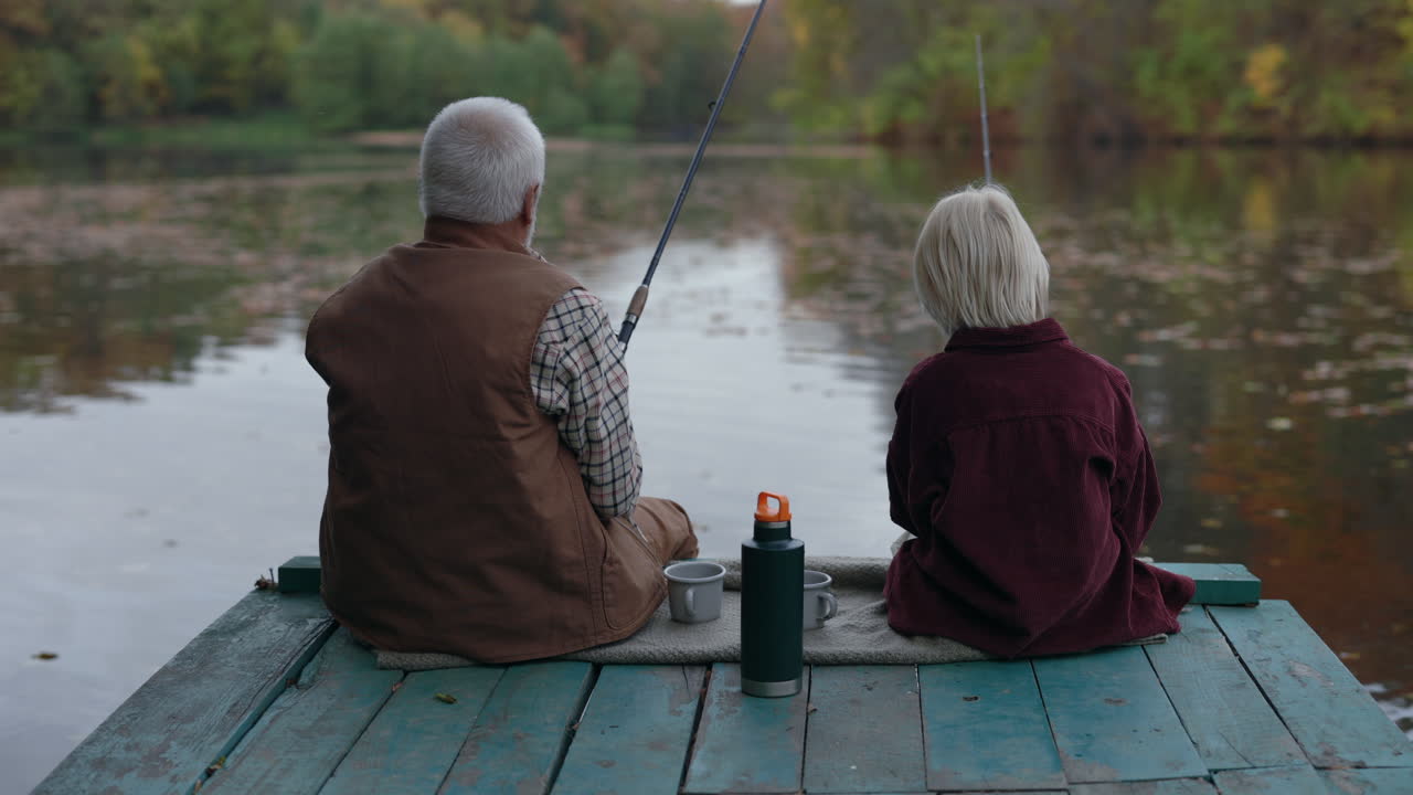 Grandfather and Grandchild Fishing on a Lake Pier