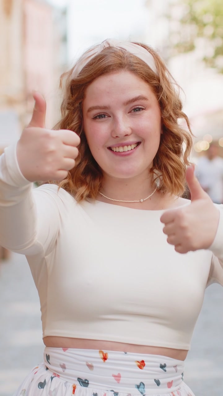 Happy woman showing thumbs up like sign positive something good positive feedback in city street