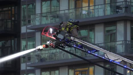 Firefighter-Extinguish-Fire-and-Spraying-Water-from-Crane,-Medium