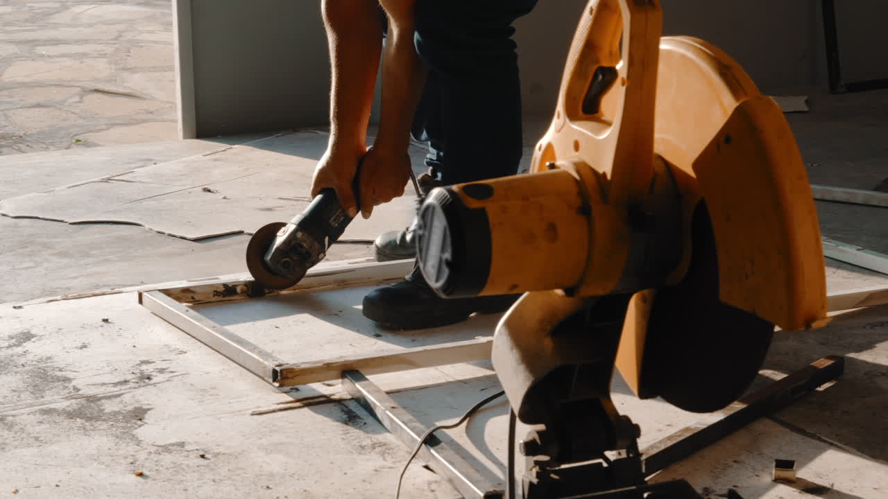 Blacksmith Polishing Metal Frame With A Grinder, Working Next To A Cut-off Machine