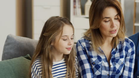 primer plano de los padres sonrientes y de buen aspecto y dos niños sentados uno al lado del otro y mirando el libro o las fotografías con una sonrisa