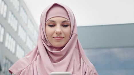 mujer en hijab usando teléfono