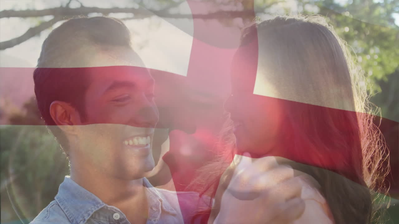 Holding Danish flag, smiling couple outdoors in bright sunlight with animation