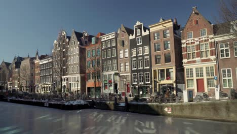 Frozen-Oudezijds-Voorburgwal-canal-in-the-Red-light-district-of-De-Wallen,-covid-19-pandemic-lockdown-with-an-empty-street,-Amsterdam,-The-Netherlands