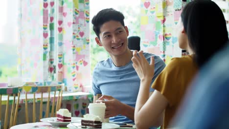카페 에 있는 젊은 부부 의  ⁇ 드헬드 화면
