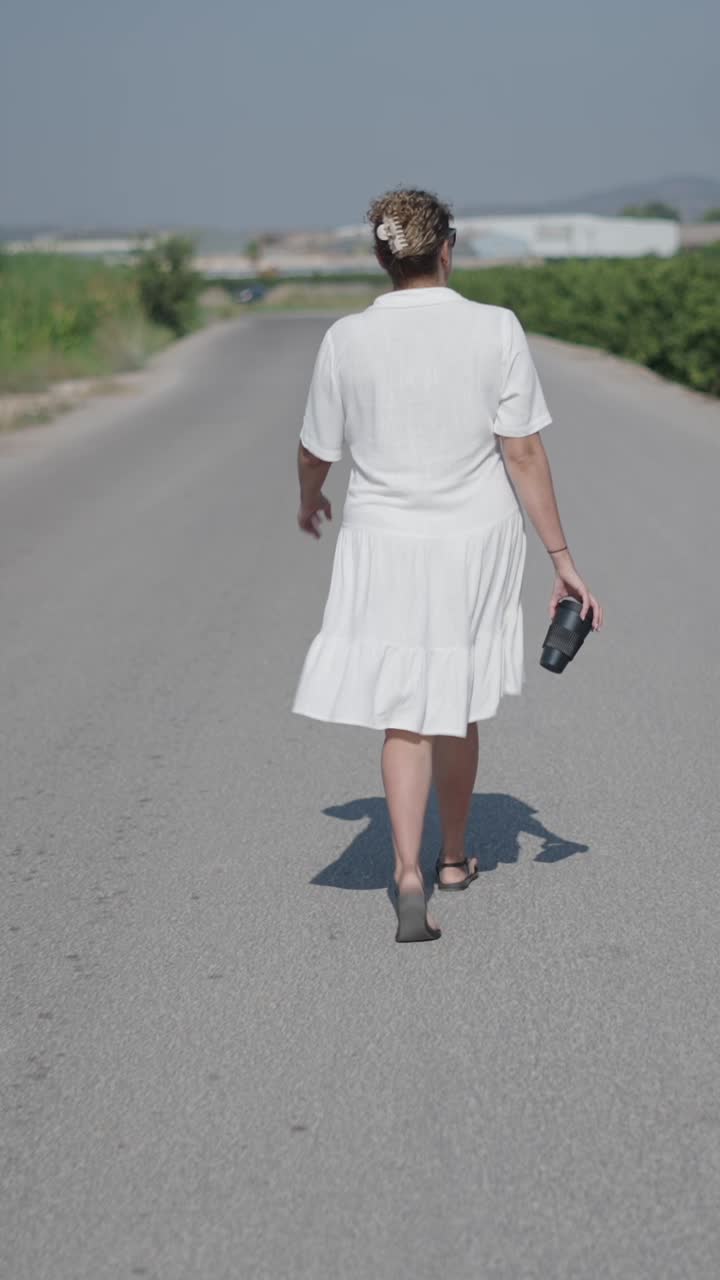 Wanita berbaju putih berjalan di jalan