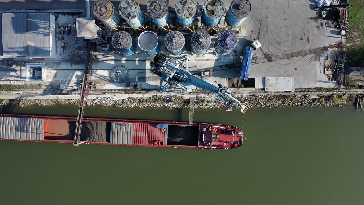 굴삭기는 배에서 트럭으로 가고를 내립니다.