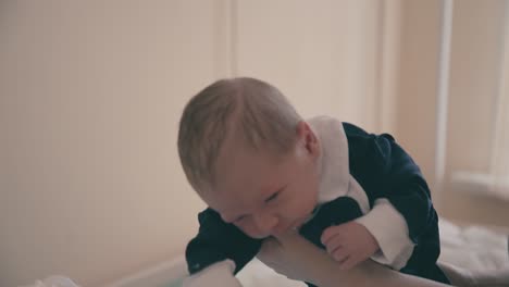 father demonstrates baby wearing festive tuxedo in room