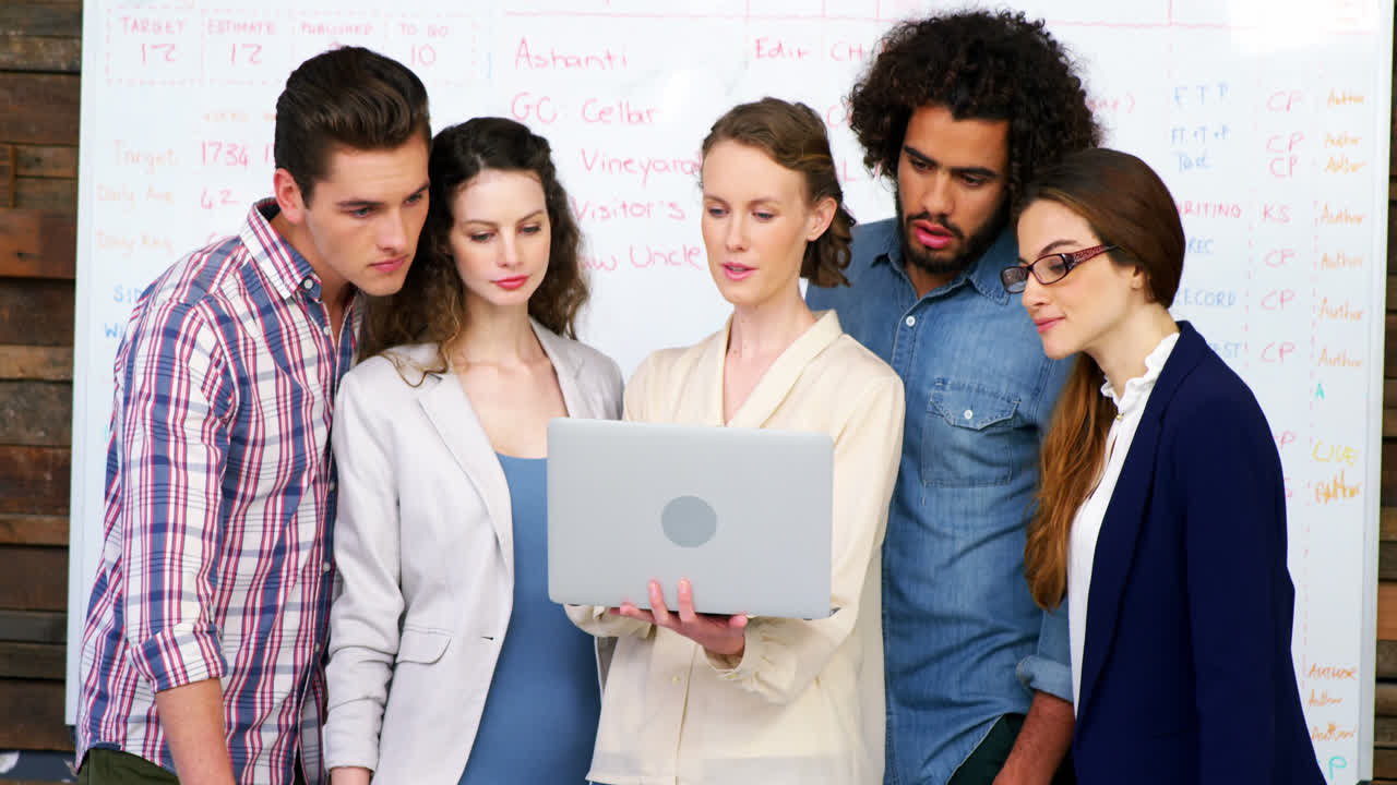 Dirigenti aziendali che discutono davanti a un laptop in riunione